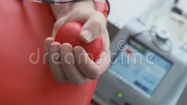关闭手抓红色应力球。 献血程序。 输血站。 捐赠设备